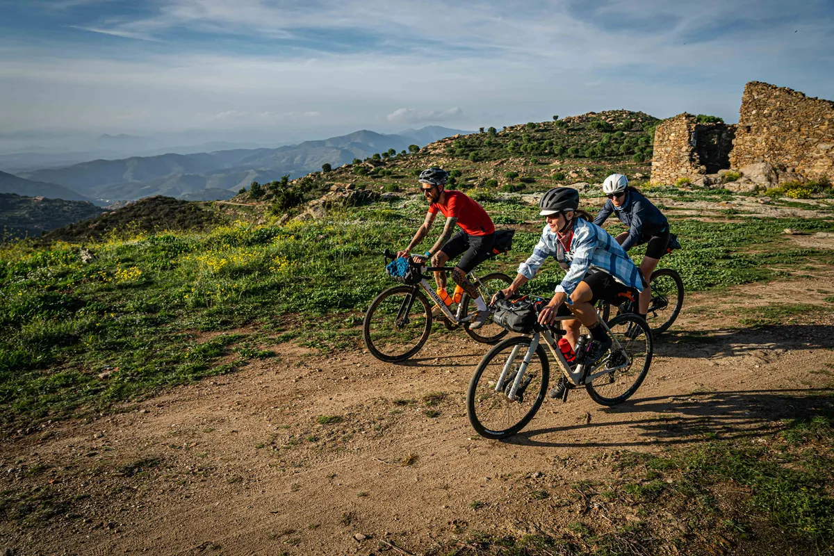 A group of cyclists riding off-road on a bikepacking trip