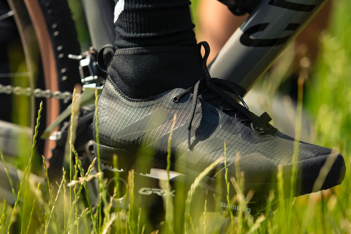 Close up of Adidas The Gravel Shoe in black with grass in the foreground