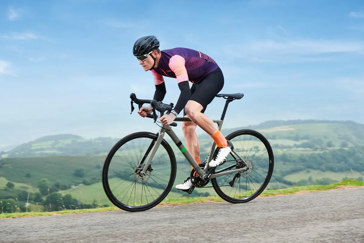 Male cyclist in purple riding the Cannondale CAAD13 Disc 105 road bike
