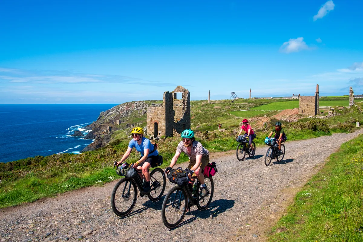 Katherine Moore (Unpaved podcast), Sam Jones (Cycling UK), Sophie Gordon (Cycling UK) and Vedangi Kulkarni (freelance) cycle past the Crown Mines at Botallack during a recce ride of Cycling UK's West Kernow Way, June 2021. The 230km route is part of the EU-funded EXPERIENCE project to develop sustainable year-round tourism activities in Cornwall.