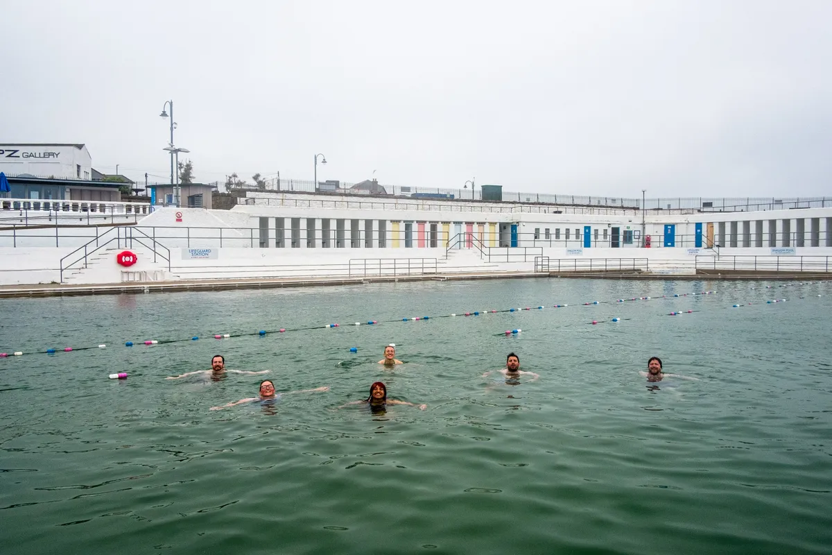 A group of riders enjoy a refreshing dip in Jubilee Pool after completing a recce ride of Cycling UK's West Kernow Way, June 2021. The 230km route is part of the EU-funded EXPERIENCE project to develop sustainable year-round tourism activities in Cornwall.