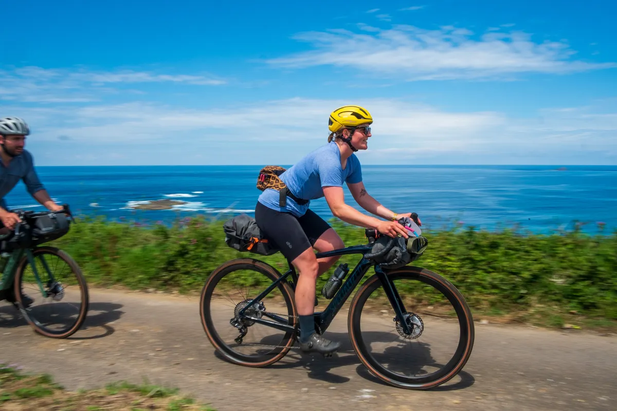 Katherine Moore (Unpaved podcast) and Stefan Amato (Pannier) cycle towards Sennen Cove during a recce ride of Cycling UK's West Kernow Way, June 2021. The 230km route is part of the EU-funded EXPERIENCE project to develop sustainable year-round tourism activities in Cornwall.