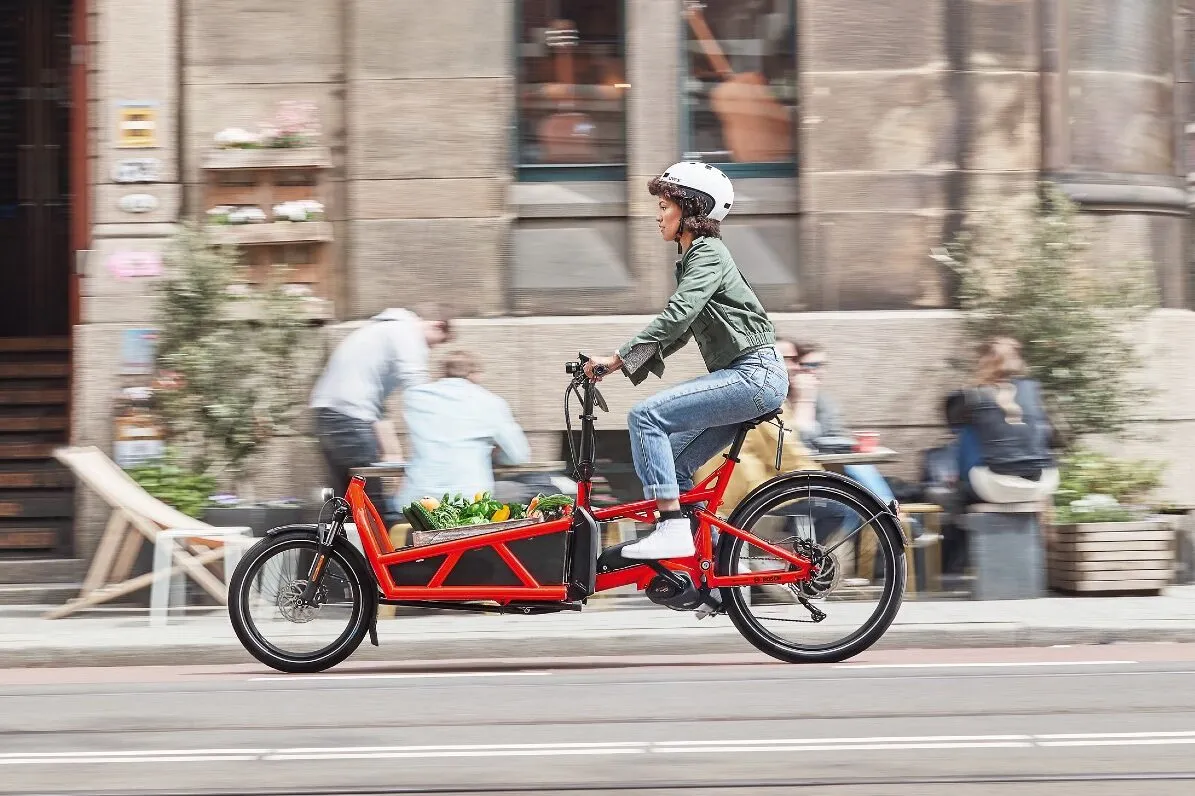 A woman riding an electric cargo bike