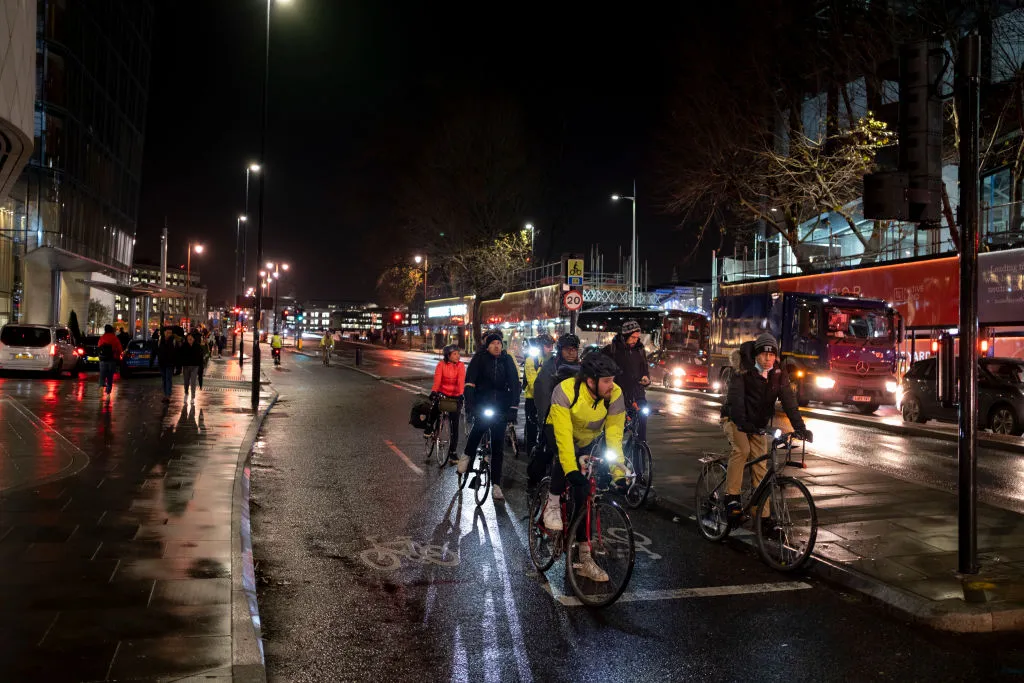 Cyclists lined up at traffic lights at night in London