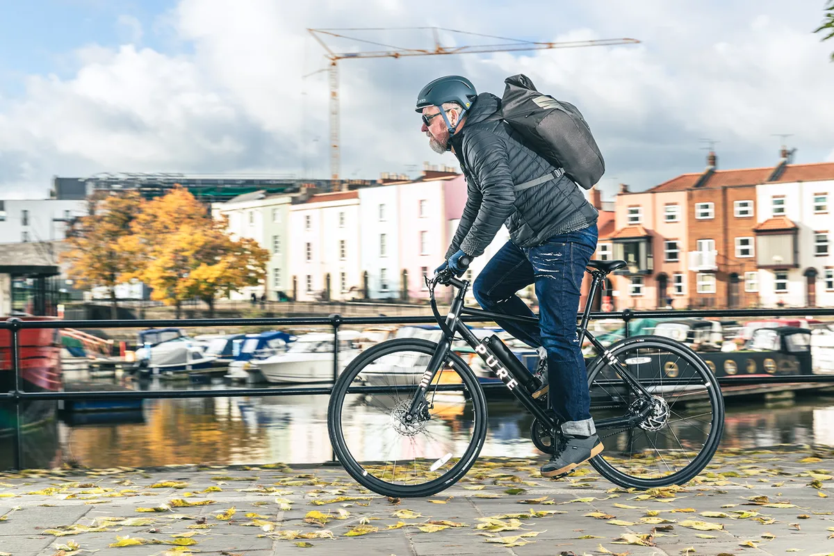 Male cyclist in black riding the Pure Electric Flux One eBike