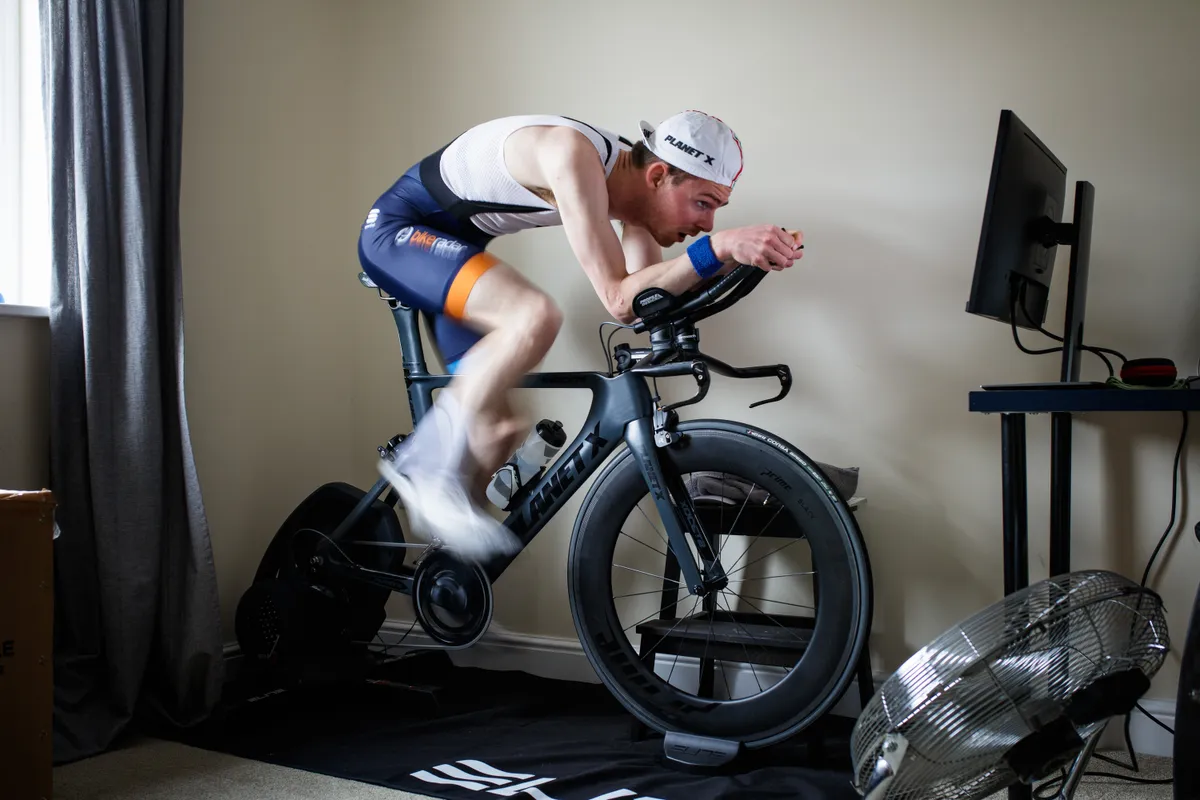 Simon von Bromley riding a time trial bike indoors on a smart trainer