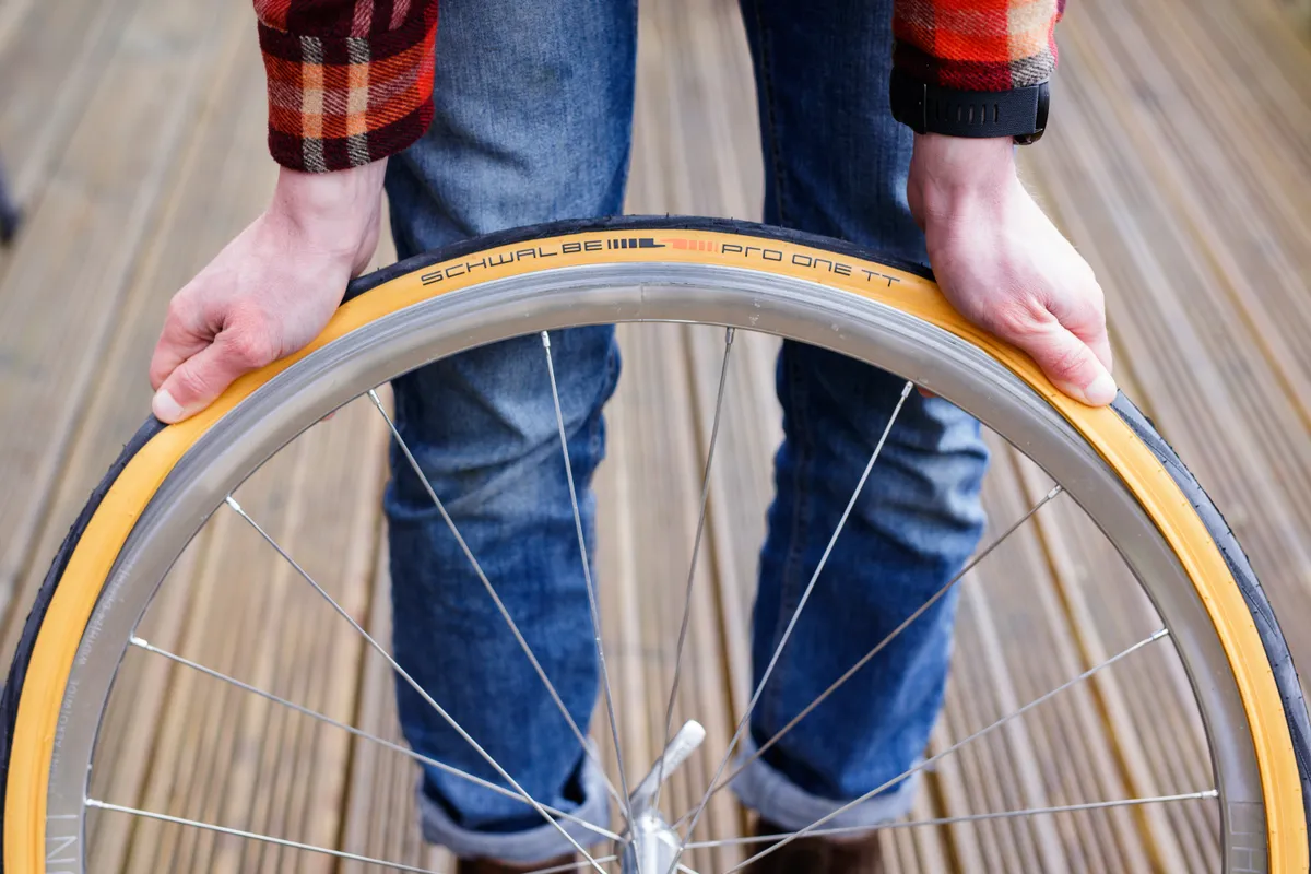 Person installing bike tyre onto a wheel