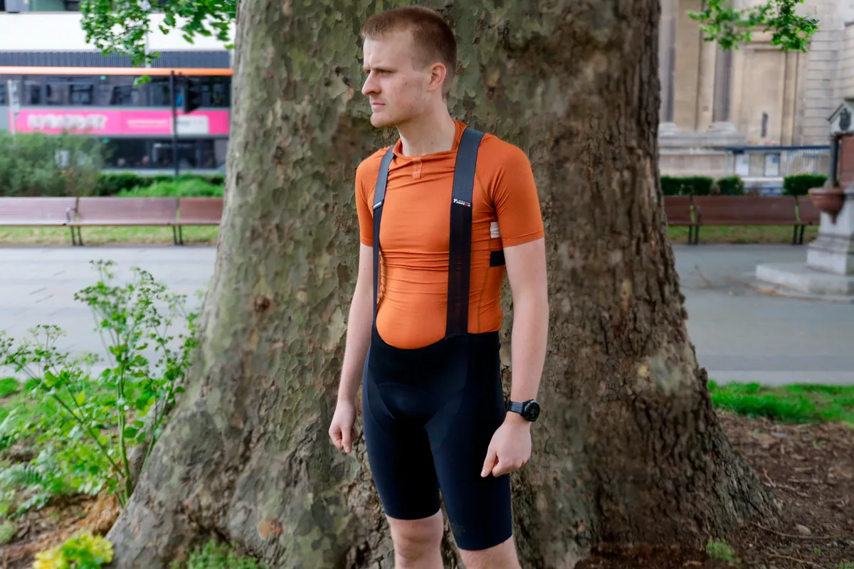 Oscar wearing Assos Equipe RSR S9 Targa bib shorts against a tree and city background