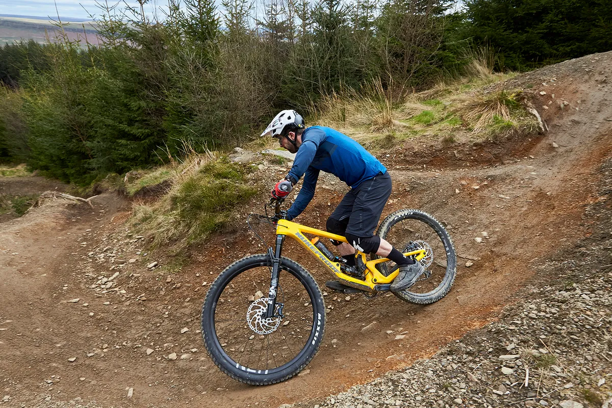 Male cyclist in blue top riding the Nukeproof Giga 297 Carbon Elite full suspension mountain bike