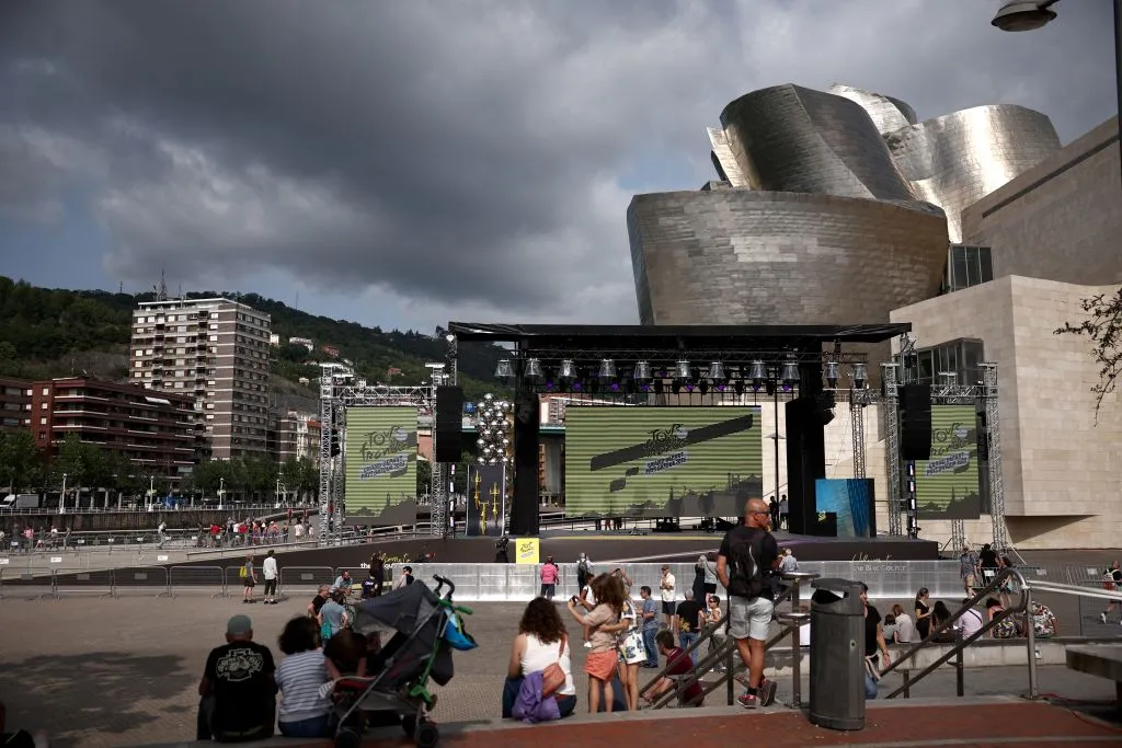 People wander at the exterior of Guggenheim Museum Bilbao, as the logo of Tour de France is displayed on a screen ahead of the 110th edition of the cycling race, in Bilbao, on June 28, 2023. The Tour de France will start in Bilbao, on July 1, 2023. (Photo by Anne-Christine POUJOULAT / AFP) (Photo by ANNE-CHRISTINE POUJOULAT/AFP via Getty Images)