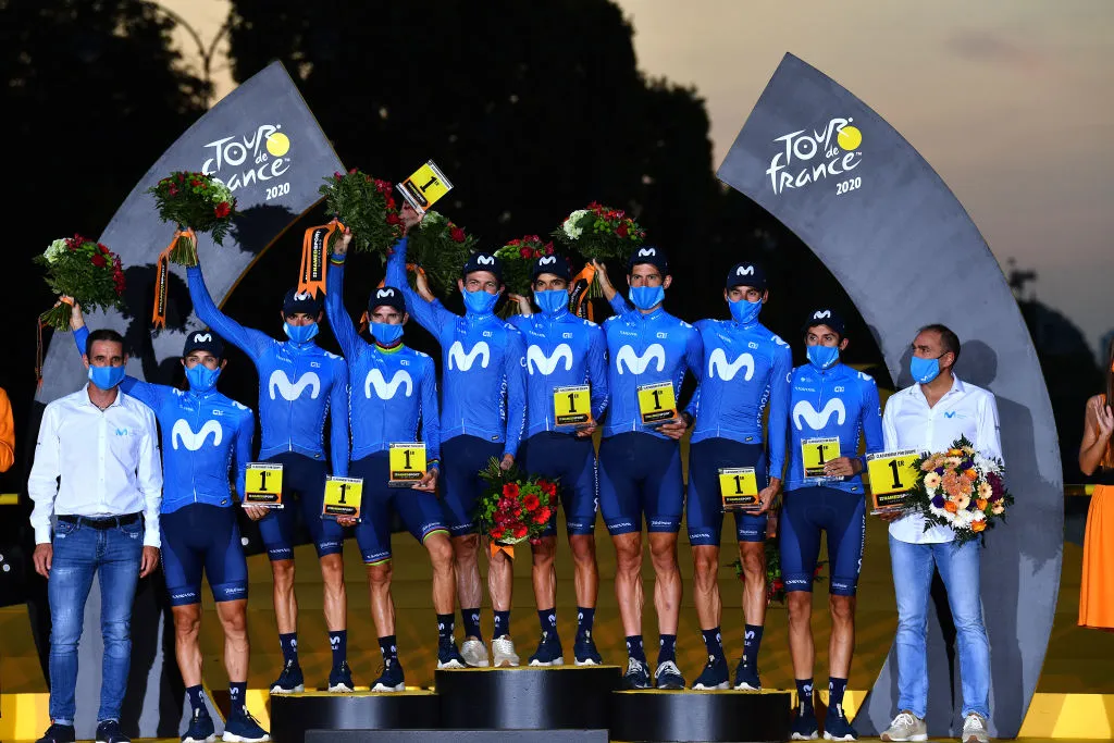 PARIS, FRANCE - SEPTEMBER 20: Podium / Dario Cataldo of Italy, Imanol Erviti of Spain, Enric Mas Nicolau of Spain, Nelson Oliveira of Portugal, Jose Joaquin Rojas Gil of Spain, Marc Soler Gimenez of Spain, Alejandro Valverde Belmonte of Spain, Carlos Verona Quintanilla of Spain and Movistar Team / Jose Luis Arrieta of Spain Sports director of Movistar Team / Pablo Lastras of Spain Sports director of Movistar Team / Best Team / Celebration / Trophy / Flowers / Mask / Covid safety measures / during the 107th Tour de France 2020, Stage 21 a 122km stage from Mantes-La-Jolie to Paris Champs-Élysées / #TDF2020 / @LeTour / on September 20, 2020 in Paris, France. (Photo by Stuart Franklin/Getty Images,)