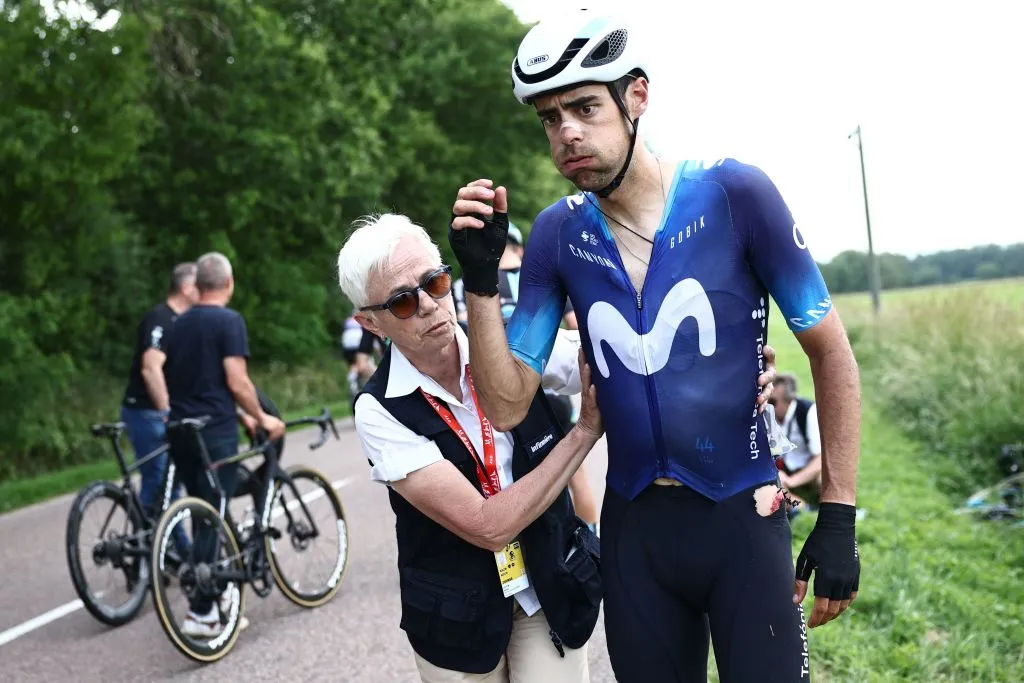 Movistar Team's Spanish rider Jorge Arcas (R) receives medical assistance after he crashed in the pack during the third stage of the 75th edition of the Criterium du Dauphine cycling race, 194,5 kms between Monistrol-Sur-Loire and Le Coteau, central-eastern France, on June 6, 2023. (Photo by Anne-Christine POUJOULAT / AFP) (Photo by ANNE-CHRISTINE POUJOULAT/AFP via Getty Images)