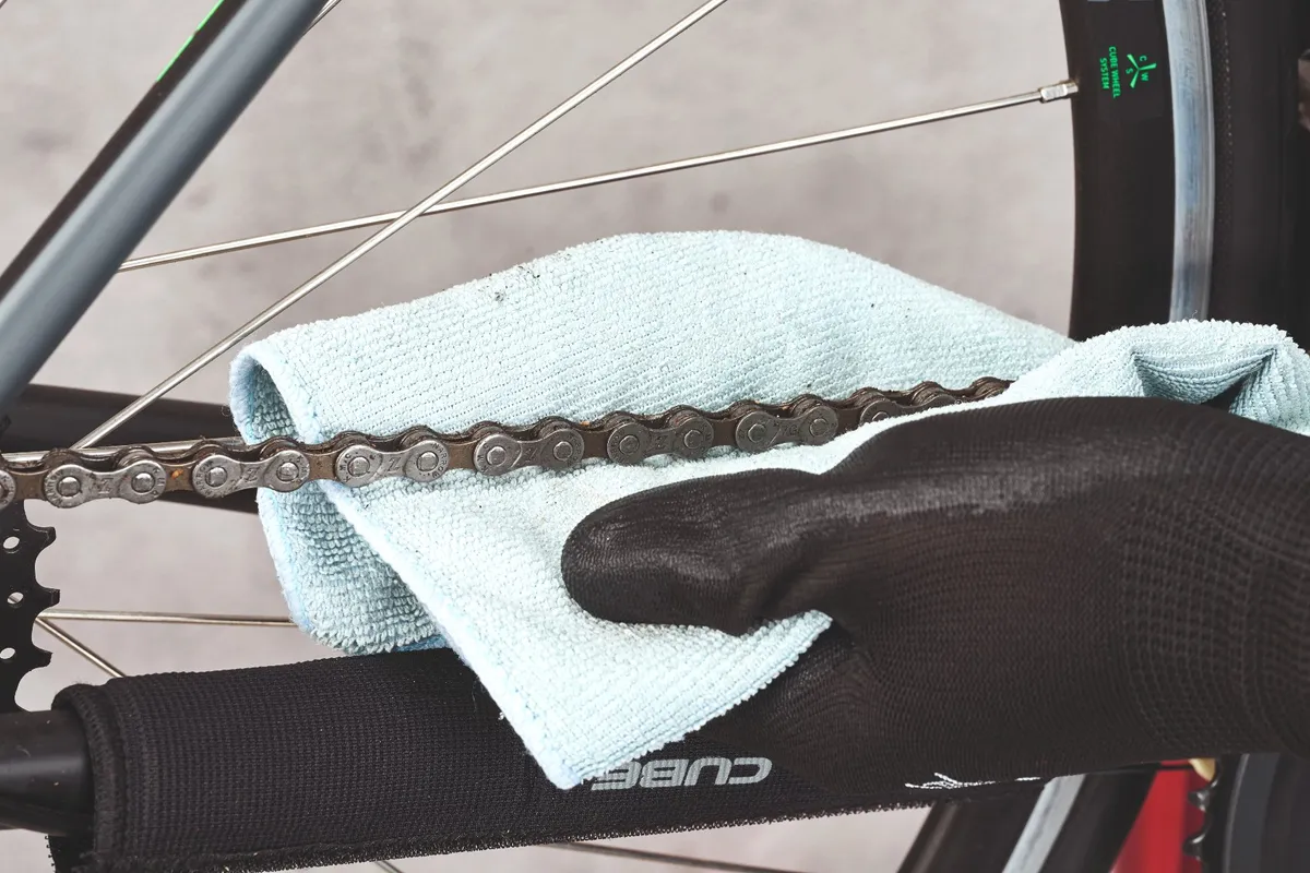 Wiping a bike chain with a clean cloth