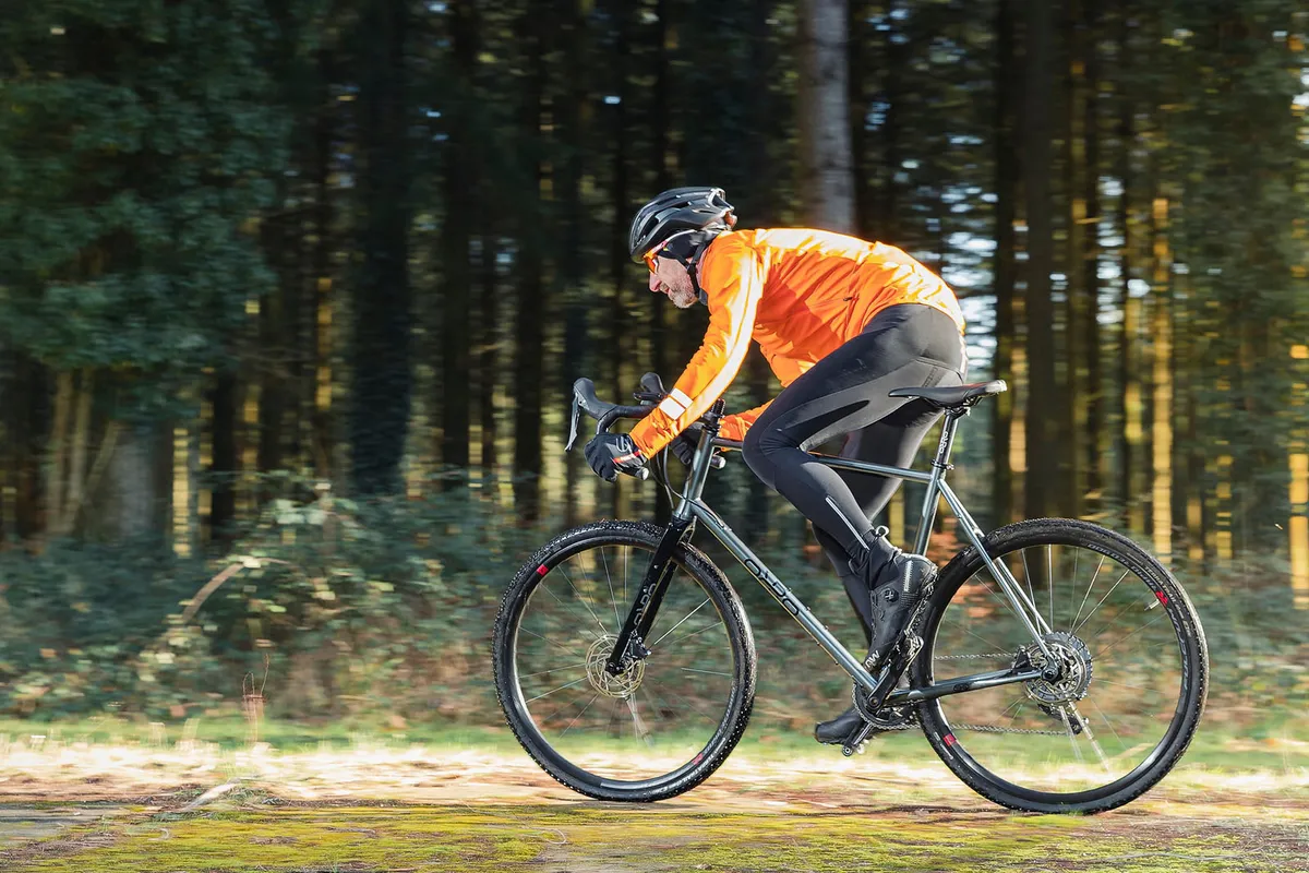 Cyclist in orange top riding the Orro Terra S GRX600 gravel bike