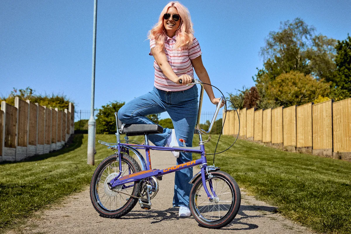 Woman posing with purple Raleigh Chopper.
