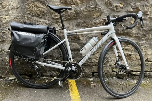 Specialized Allez Sport shown with full mudguards, a rear rack and pannier bags. A frame pump sits below the top tube.