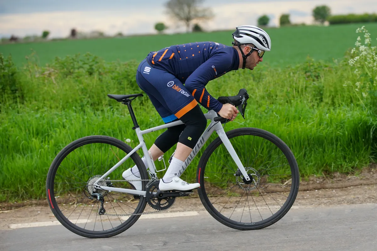 Specialized Allez Sport being ridden on a country lane. Liam Cahill sprints past, showing the drive side of the bike