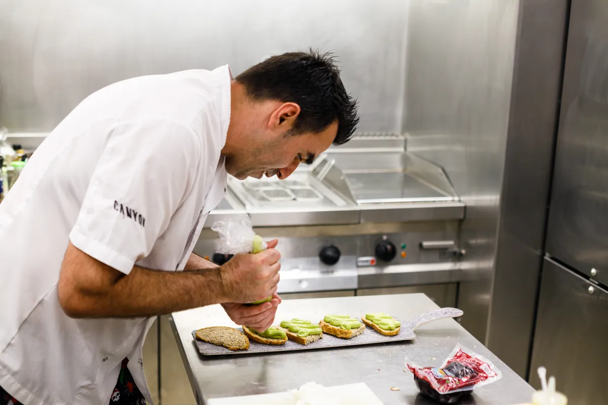 Movistar Team chef Lorenzo Pajares preparing food in the kitchen truck.