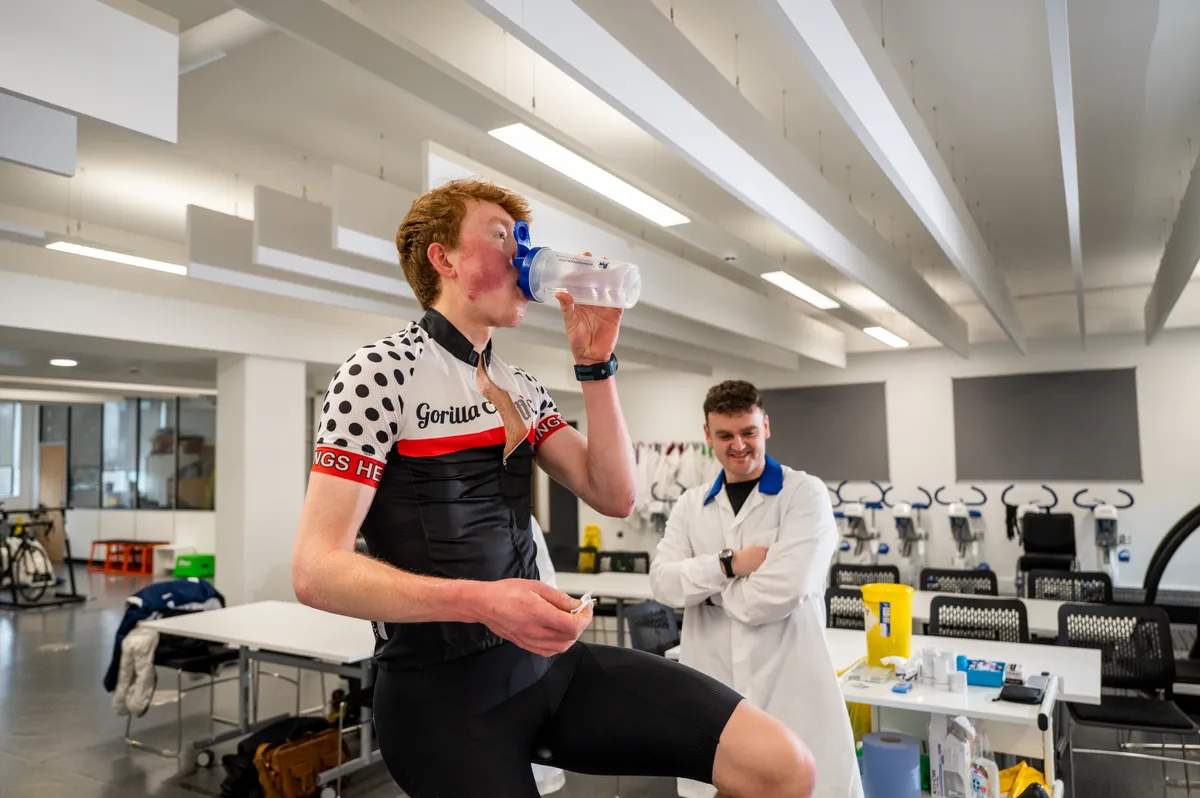 Jack Evans drinking bottle of water while riding Wattbike in laboratory