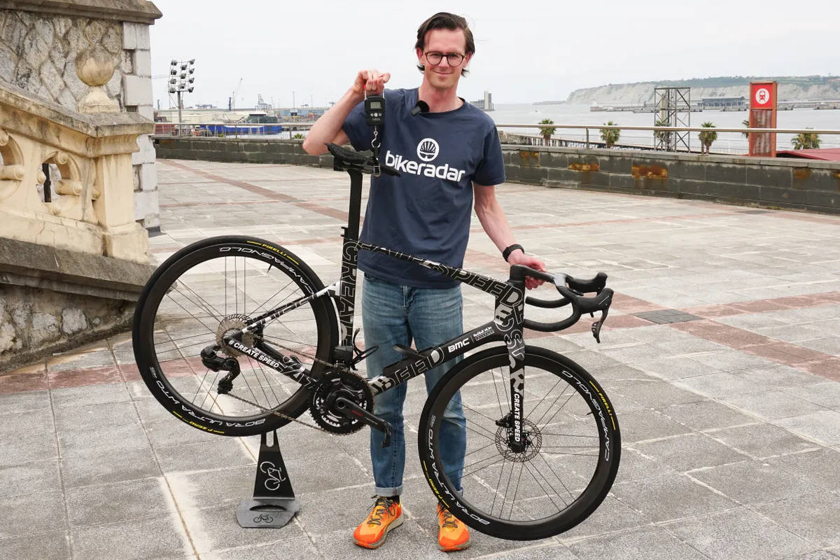 Simon von Bromley weighing Ben O'Connor's prototype BMC aero road bike before the 2023 Tour de France