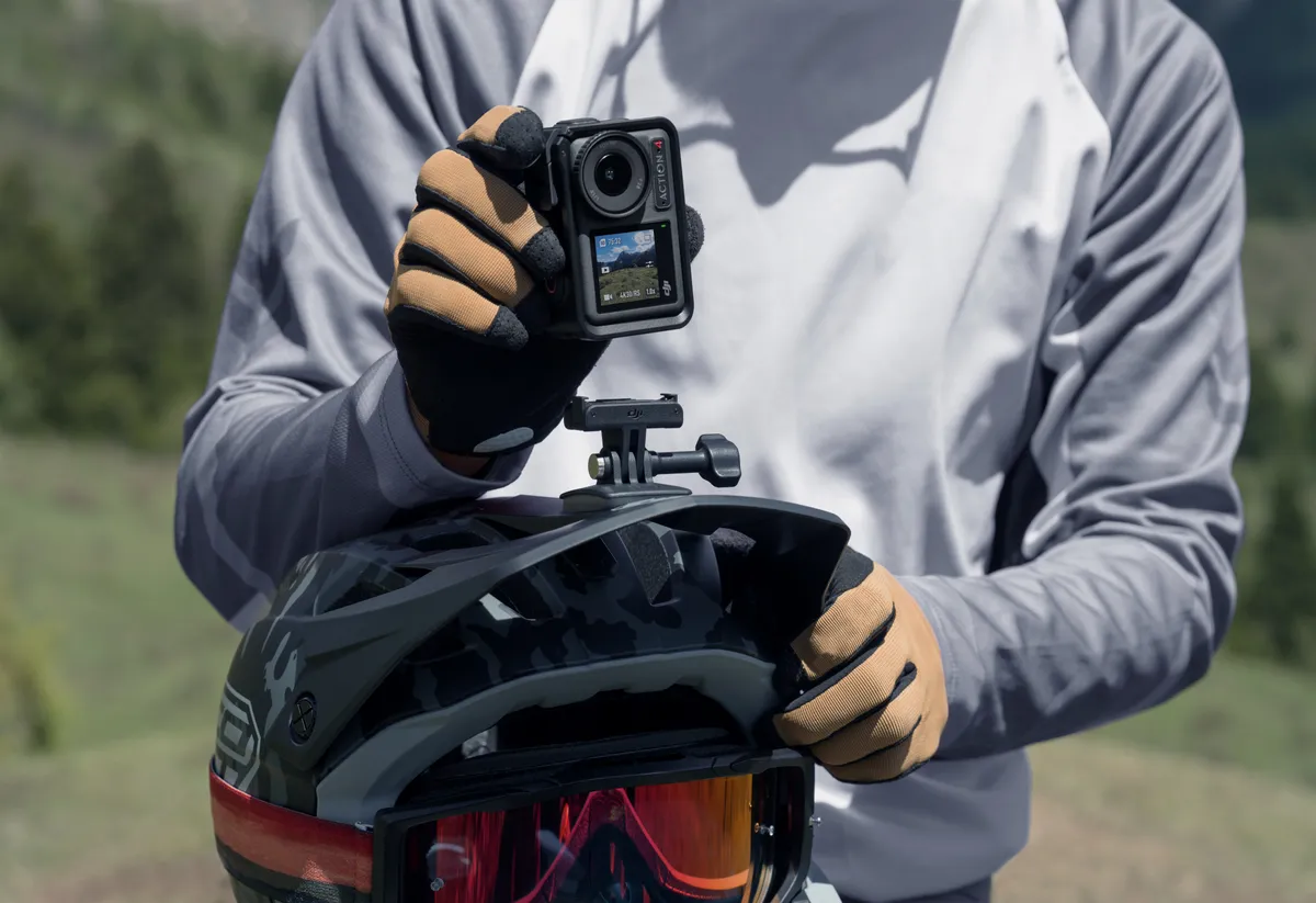 DJI Osmo Action 4 action camera mounted to full face helmet of male mountain biker