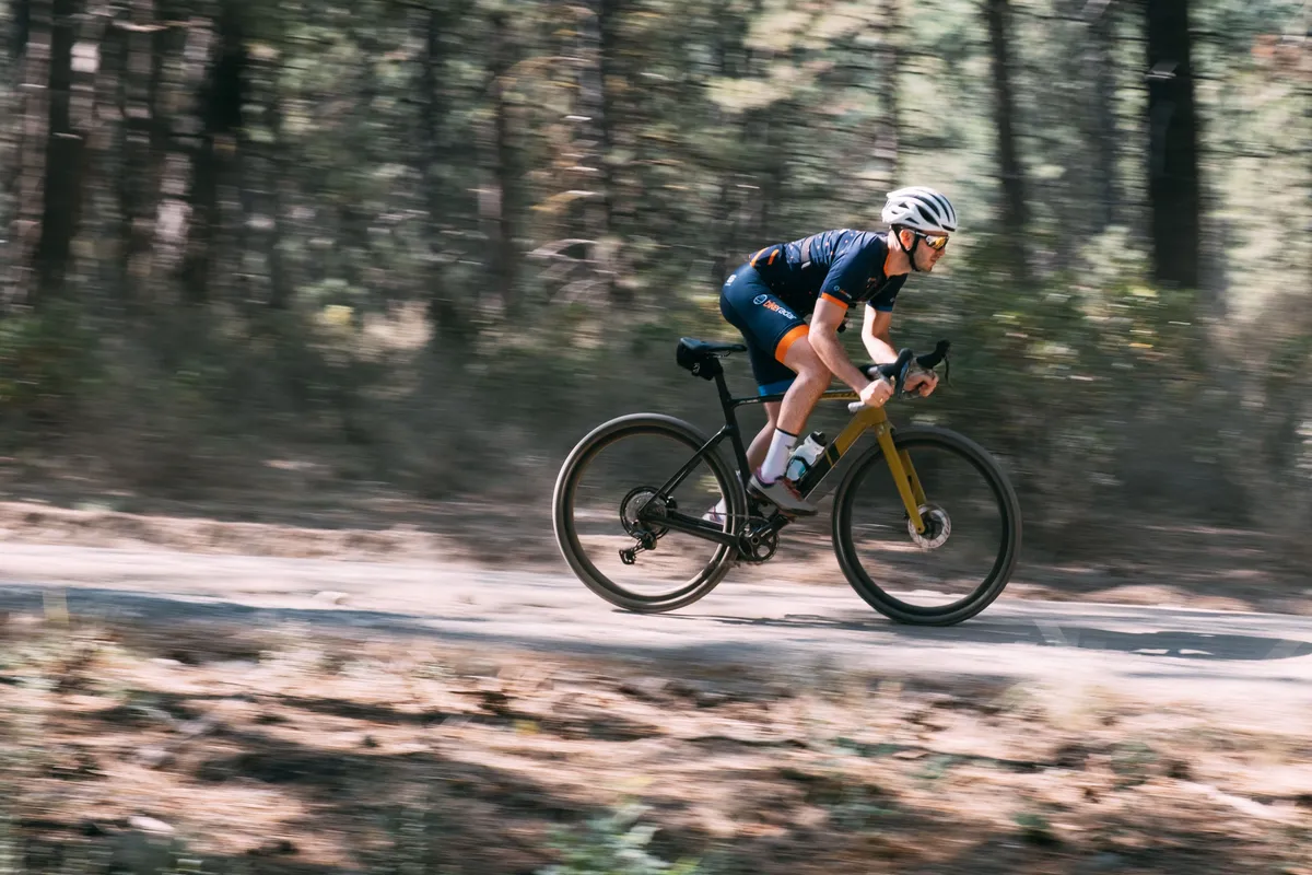 GRX RX820 being ridden on a dusty fire road. The rider sprints through the trees