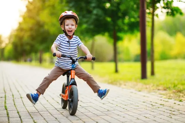 Young child riding balance bike in park