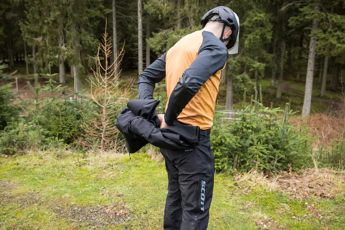 Scott Trail Storm WP Men's One Piece waterproof mountain biking suit worn by male mountain biker.