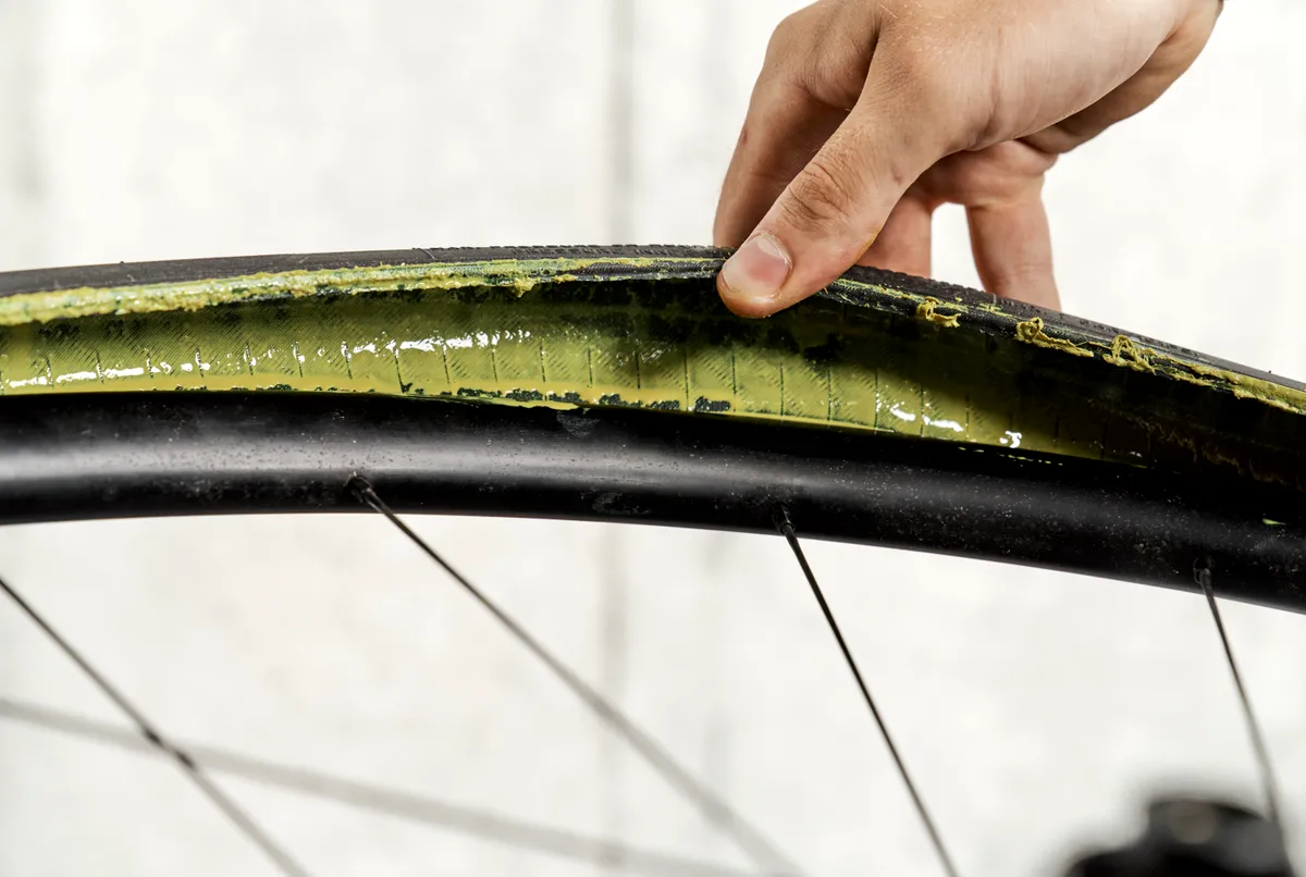 Inspecting tyre sealant levels on a Pirelli Cinturato Velo tyre.