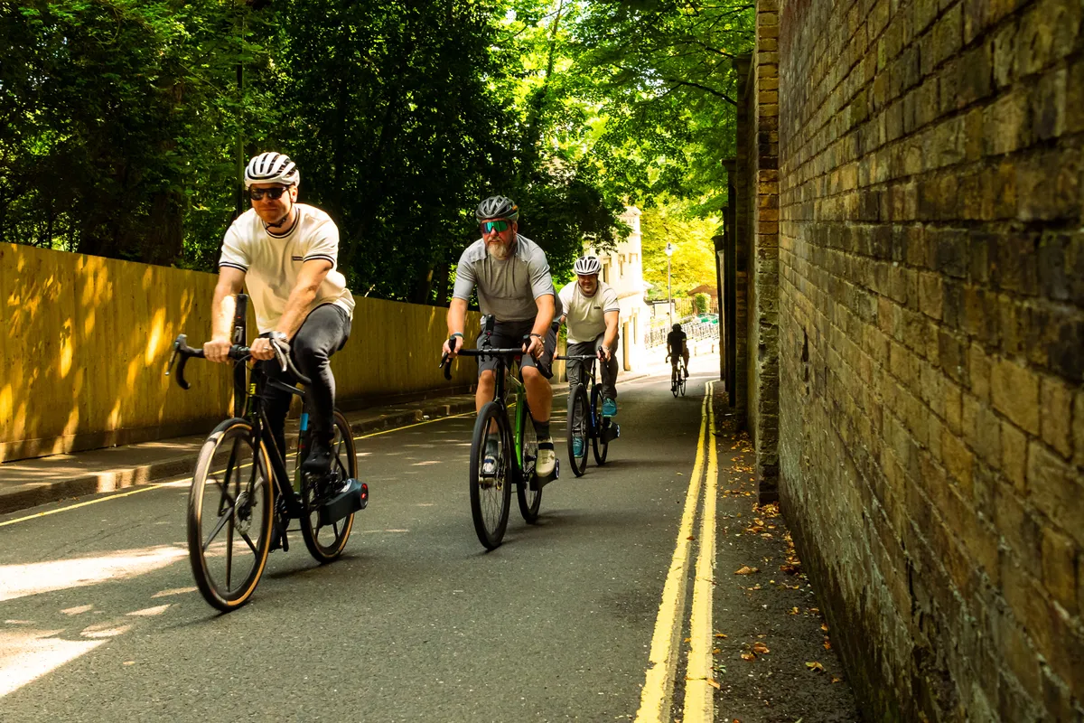 Chris Hoy and Warren Rossiter cycling up Swain's Lane.