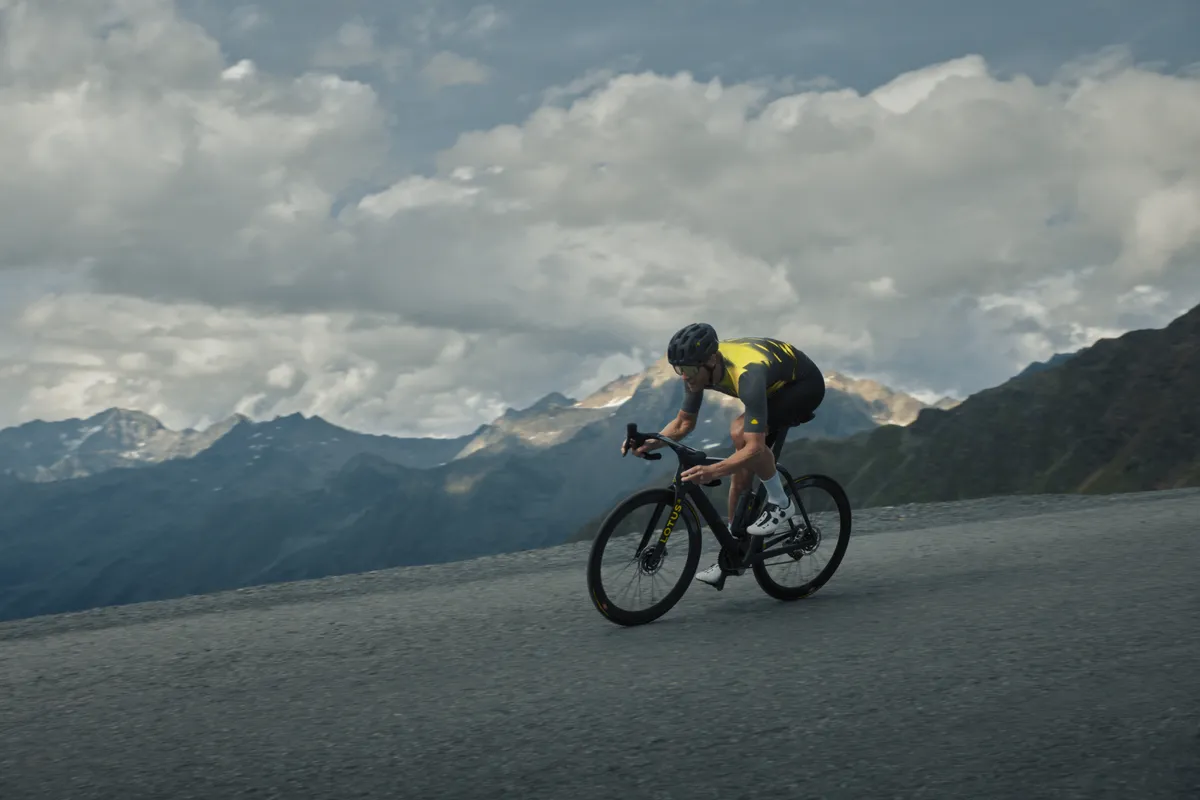 Male cyclists descending mountain road on Lotus Type 136 electric road bike