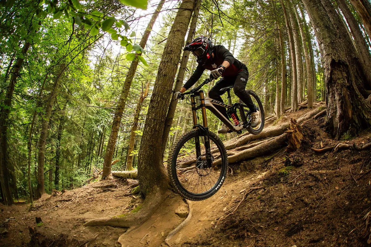 Male rider in black and red top riding the Giant Glory Advanced full suspension mountain bike