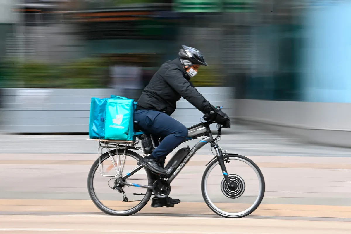 Deliveroo courier rides bike with ebike conversion kit.