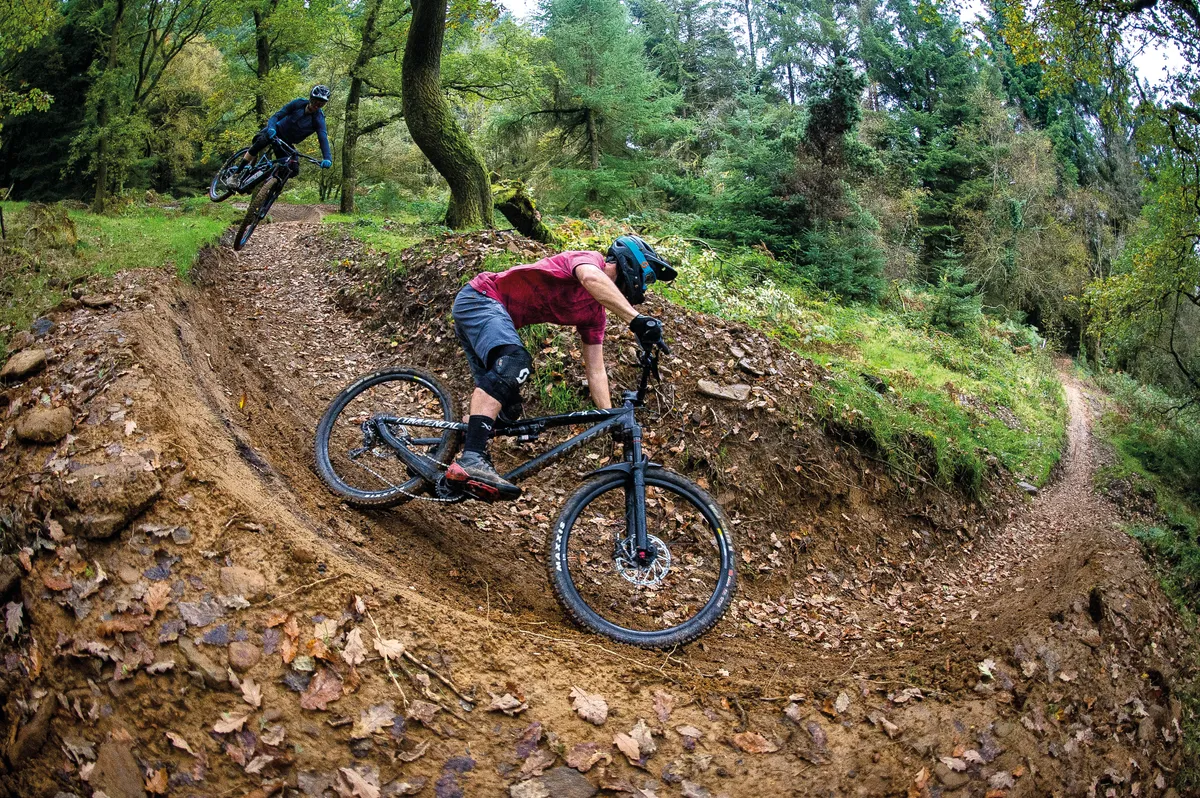 Two riders on a dirt berm at BikePark Wales