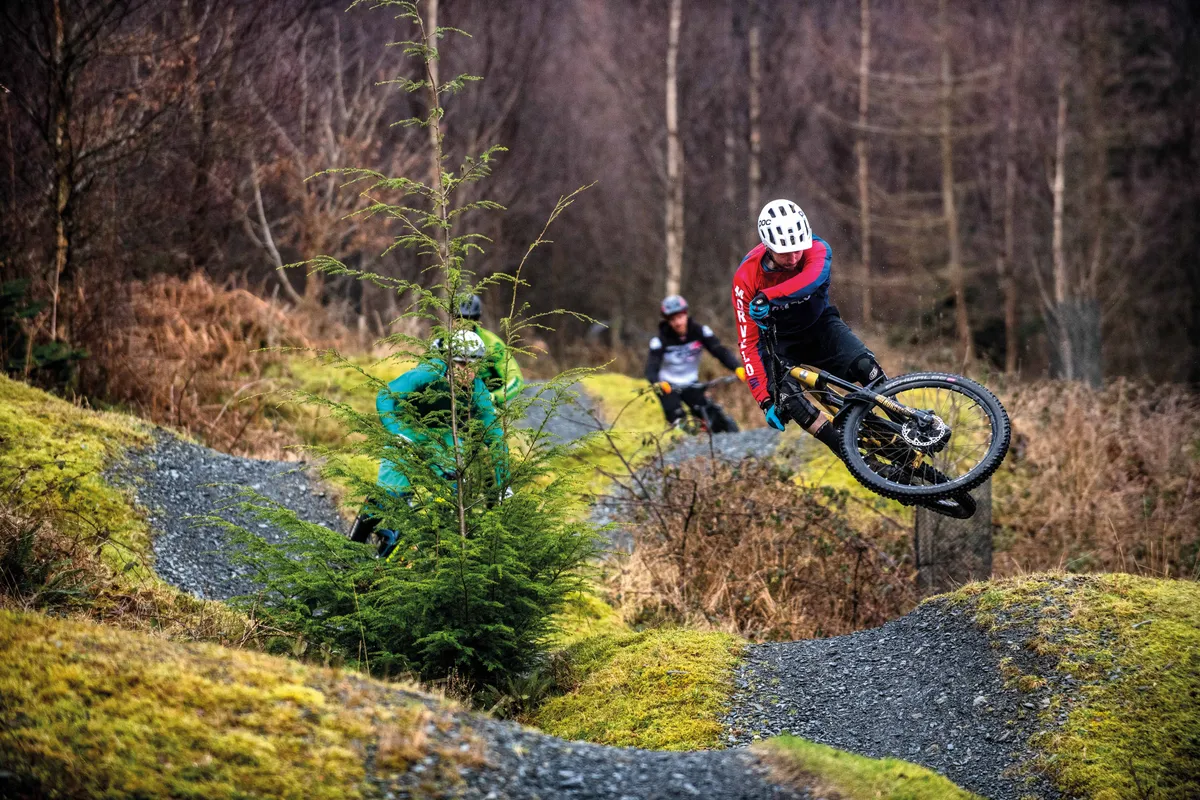 Riders hitting rolling jumps at Coed Y Brenin