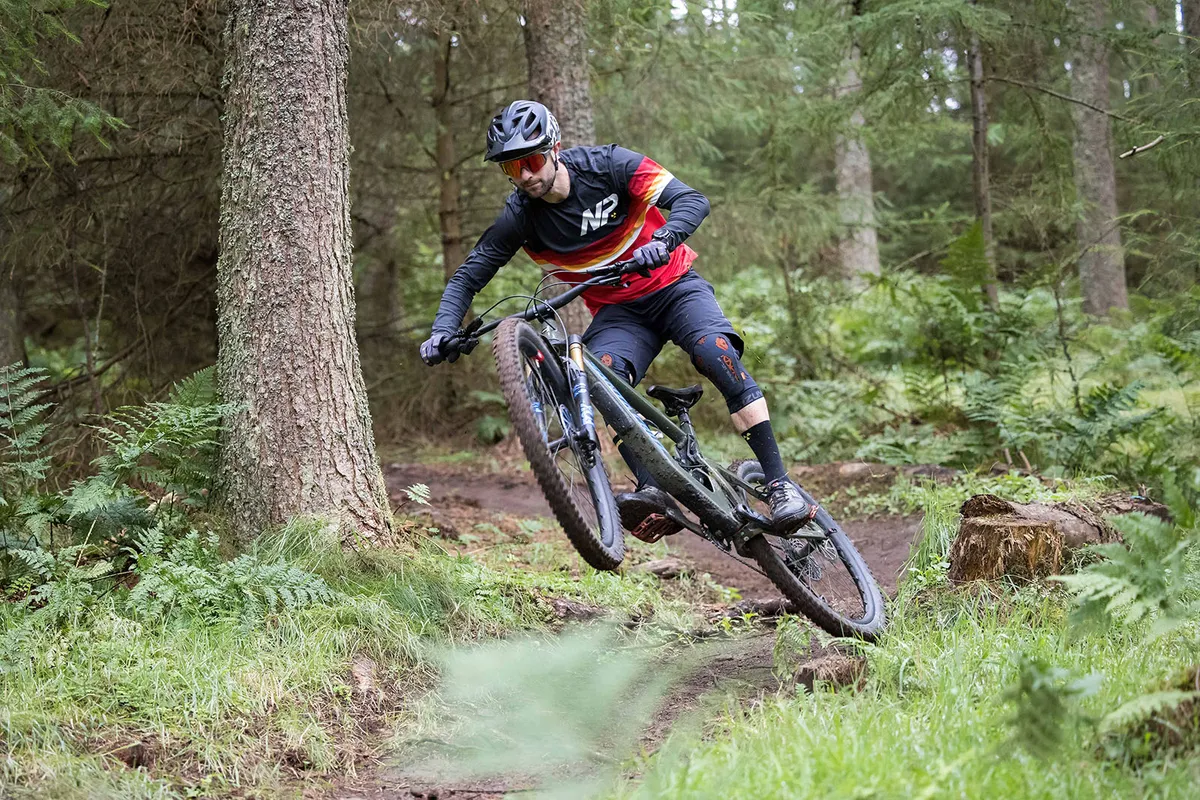 Male rider in blue and red top riding the 2022 Santa Cruz Bronson full suspension mountain bike