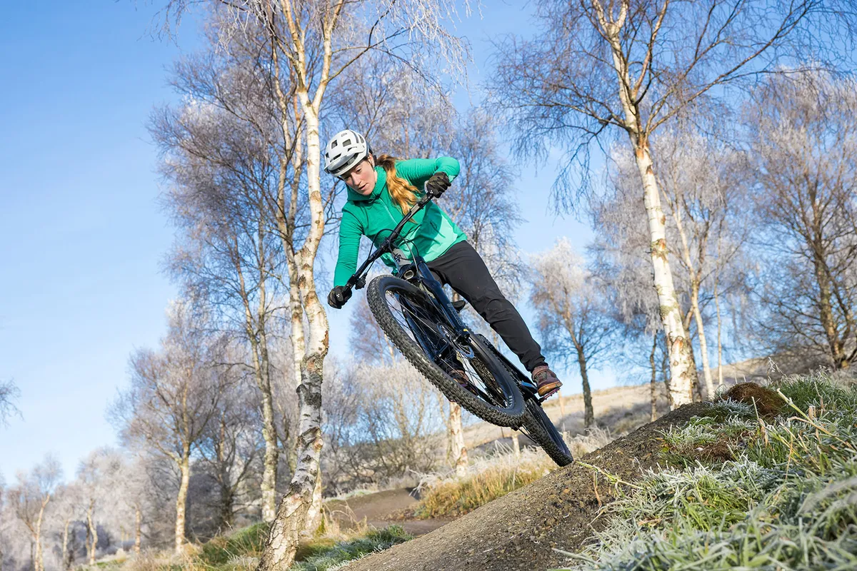 Female rider in a green top riding the GT Zaskar FS Sport full suspension mountain bike