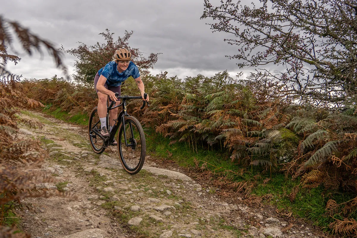 Female cyclist in blue top riding the Liv Devote Advanced Pro women's gravel bike