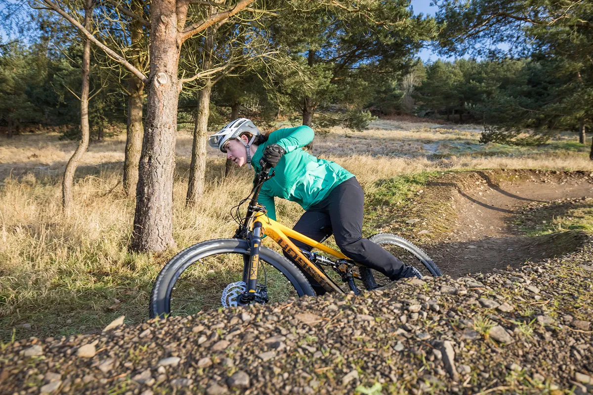Female rider in green top riding the Polygon Siskiu D6 full suspension mountain bike