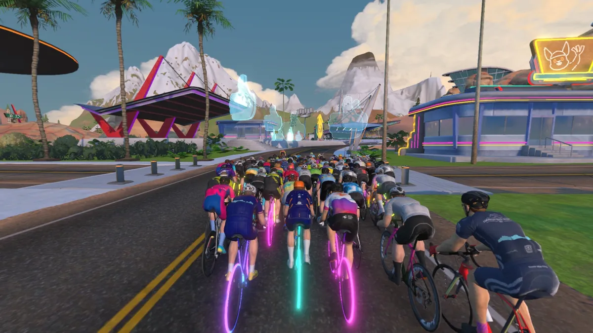 In-game graphic from Zwift showing virtual riders cycling along road.