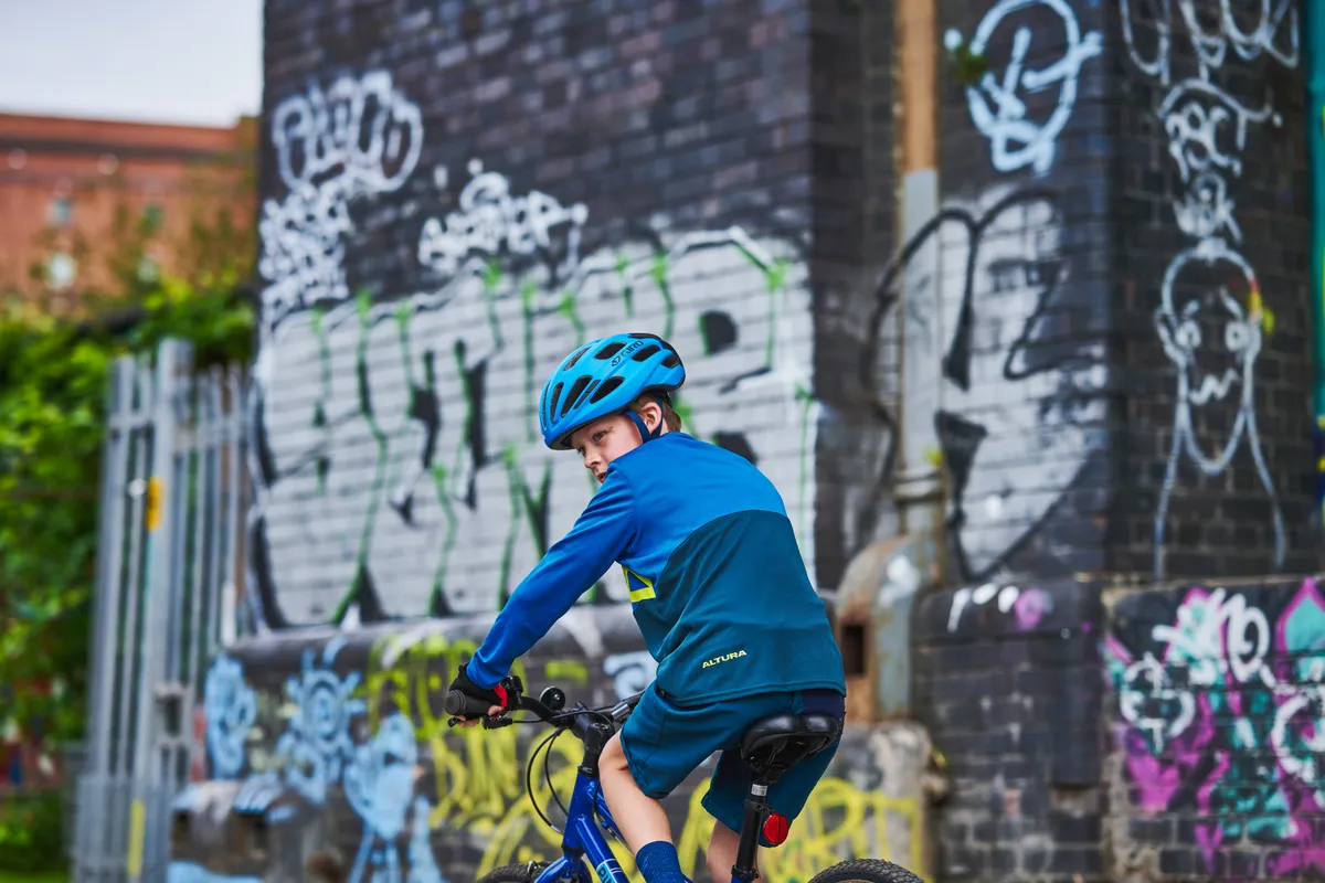 Boy looking over left shoulder while riding bike