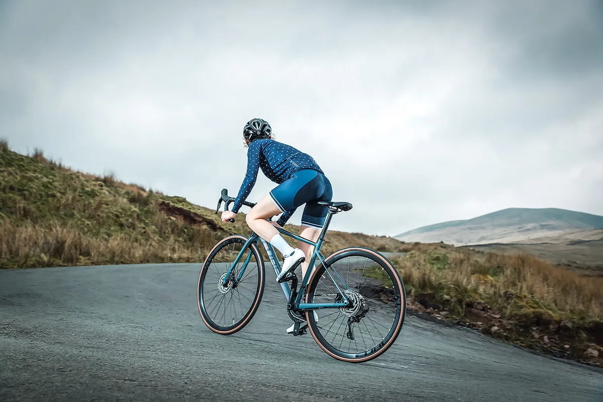 Cyclist in blue riding through hilly landscape