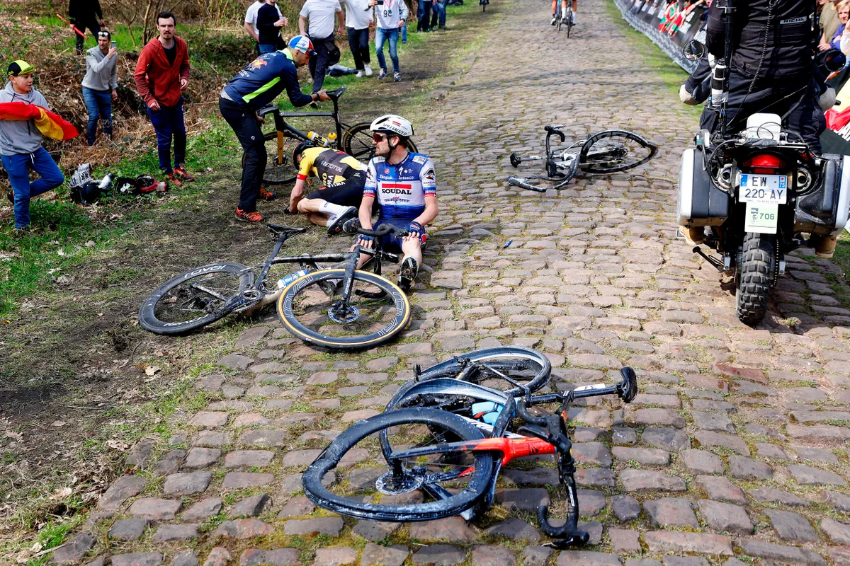 Bikes are riders lying on the cobbles after a crash during the 2023 Paris-Roubaix