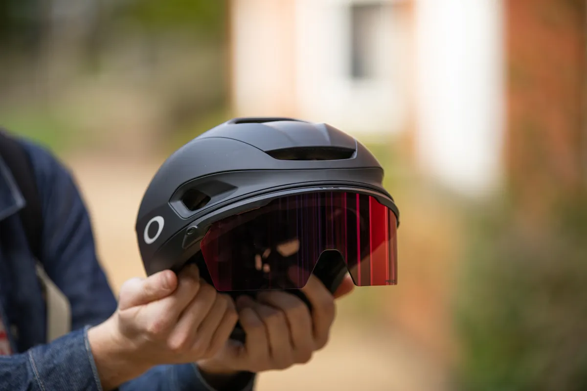 Oakley ARO 7 aero road bike helmet held in hands.