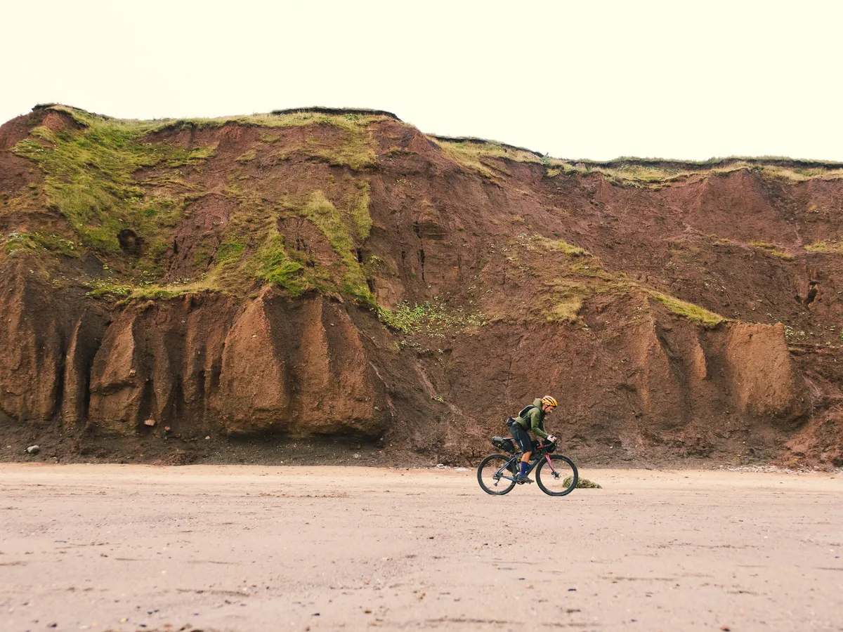 Markus Stitz riding on beach in front of cliffs