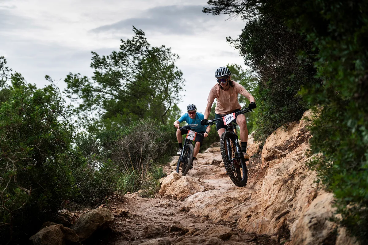 Riders riding the Orbea Oiz M-Team XTR full suspension mountain bike on dirt track