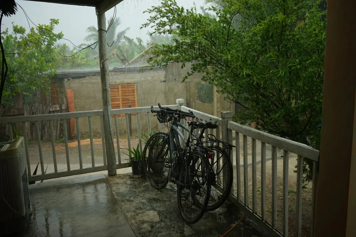 View of bikes on verranda in rain.