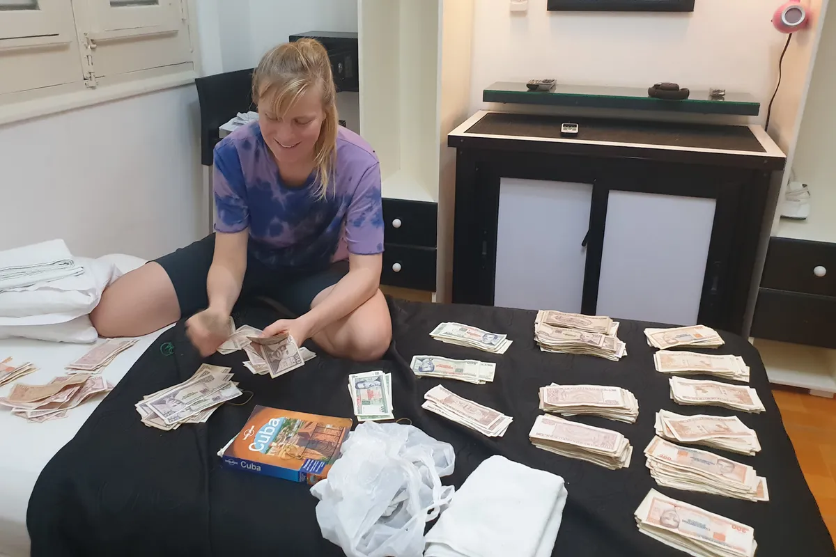 Robyn Furtado counting paper money on hotel bed.