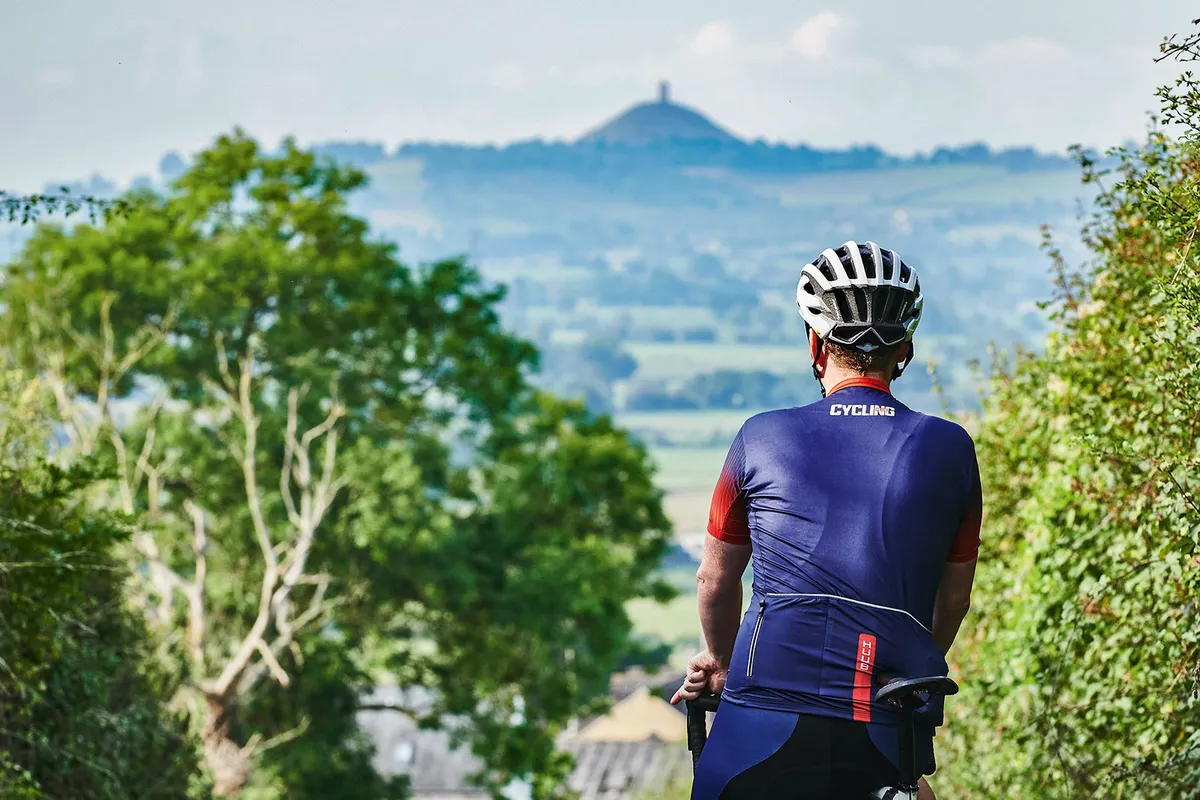 Cyclist overlooking Glastonbury Tor