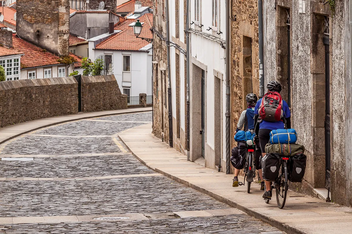 Two cyclists arriving in Santiago de Compostela after completing the camino de Santiago: Pamplona to Santiago de Compostela